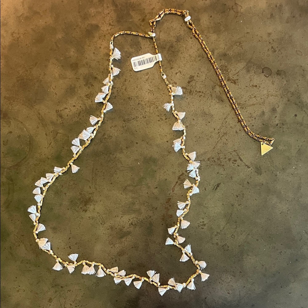 Serafina tassle necklace adjustable from 21”.   New. Grey tassles, gold detail